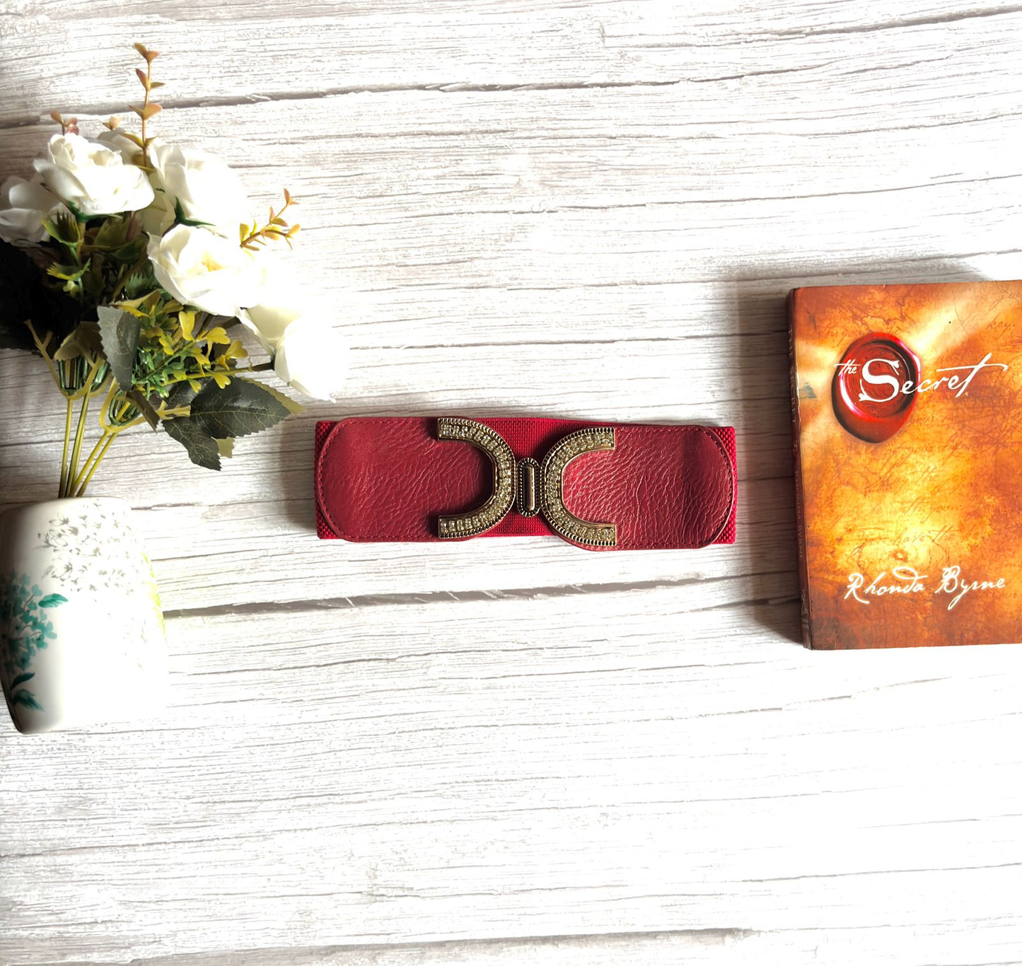Elasticated waist belt in cherry maroon with gold bow style buckle