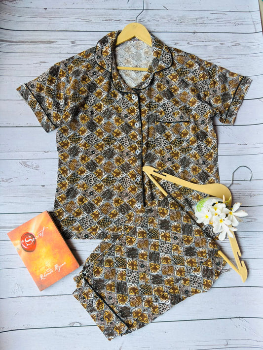 Floral-patterned dress with a yellow hair clip and orange tag on a light wooden surface