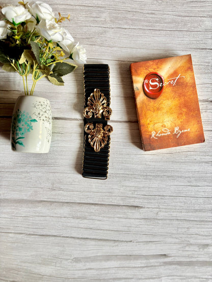 Elasticated black belt with bold and designer buckle in golden colour