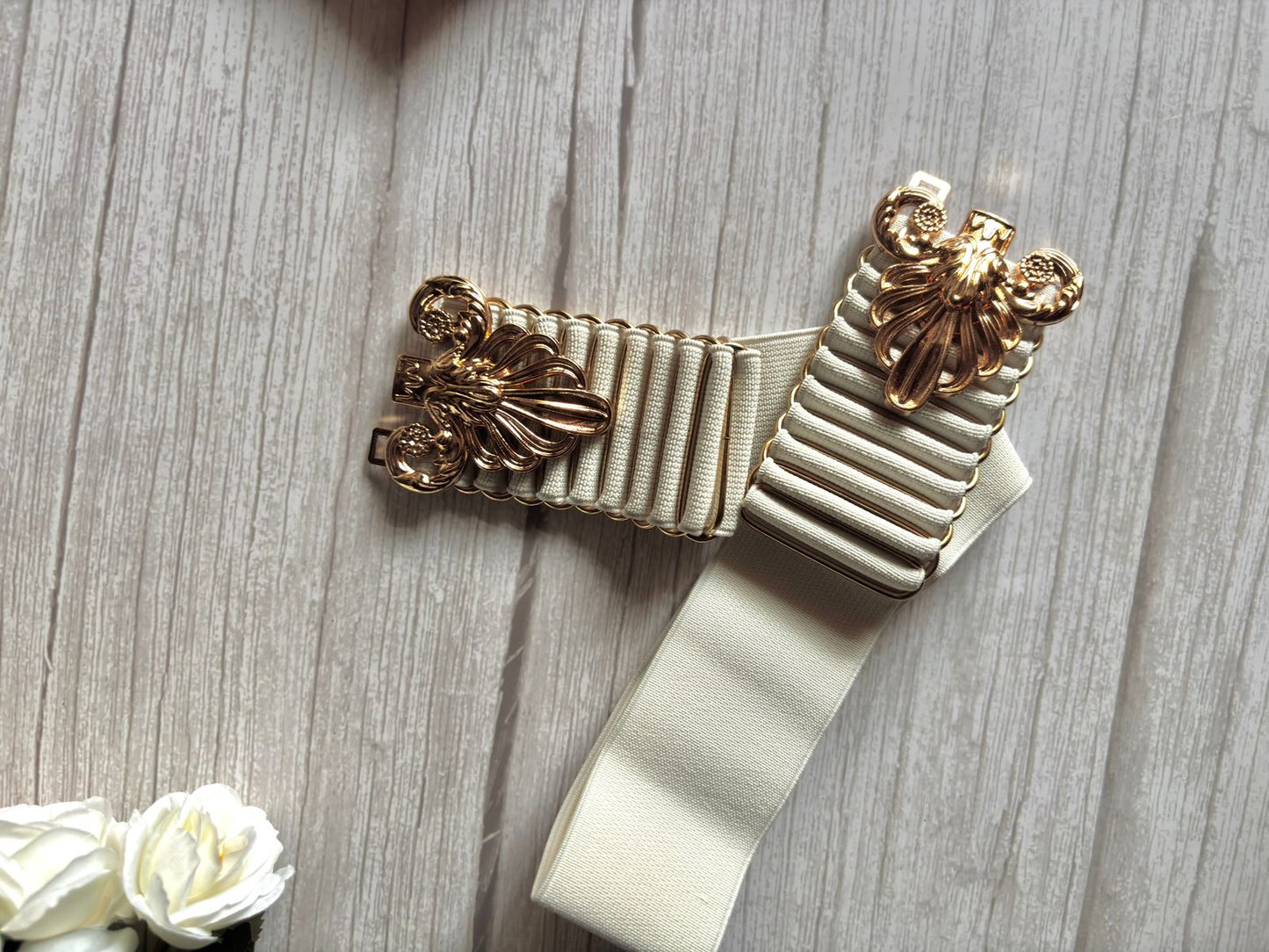 Elasticated white belt with bold and designer buckle in golden colour