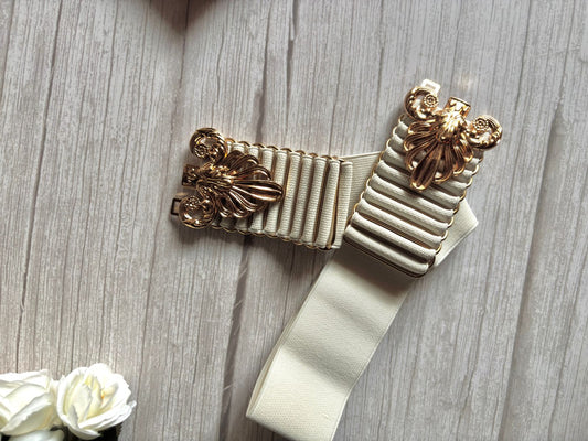 Elasticated white belt with bold and designer buckle in golden colour