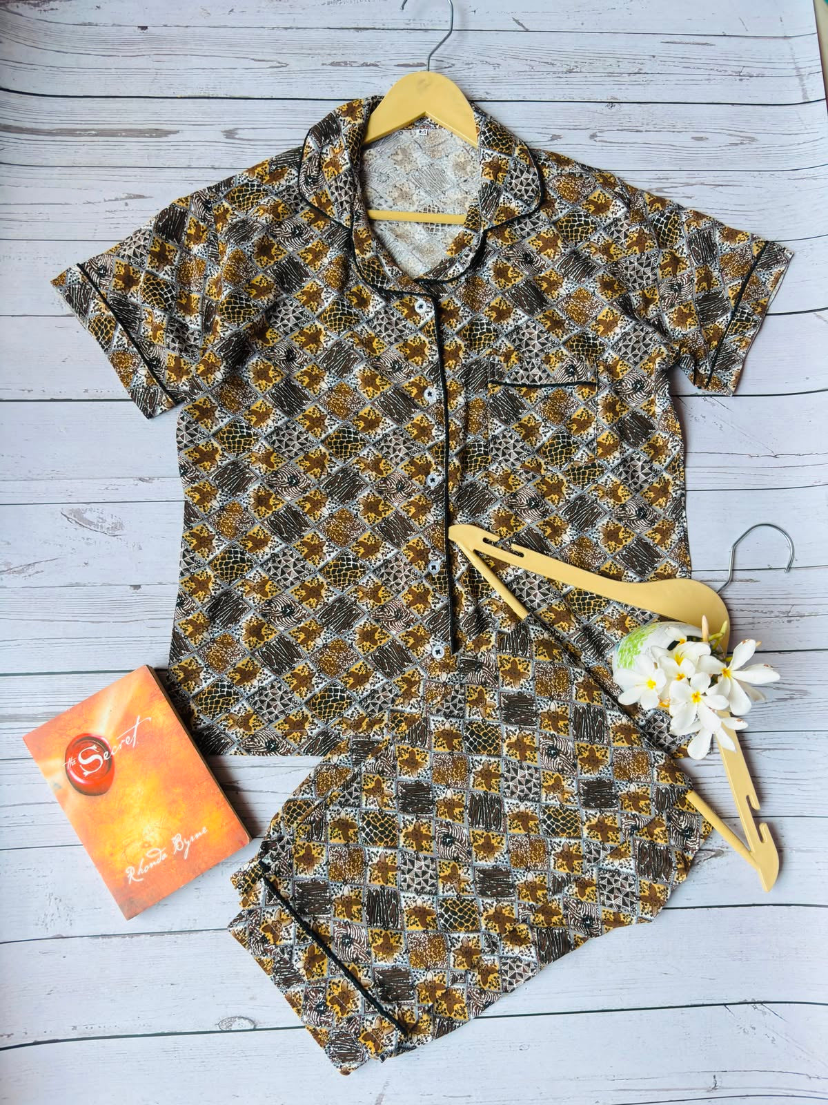 Floral-patterned dress with a yellow hair clip and orange tag on a light wooden surface