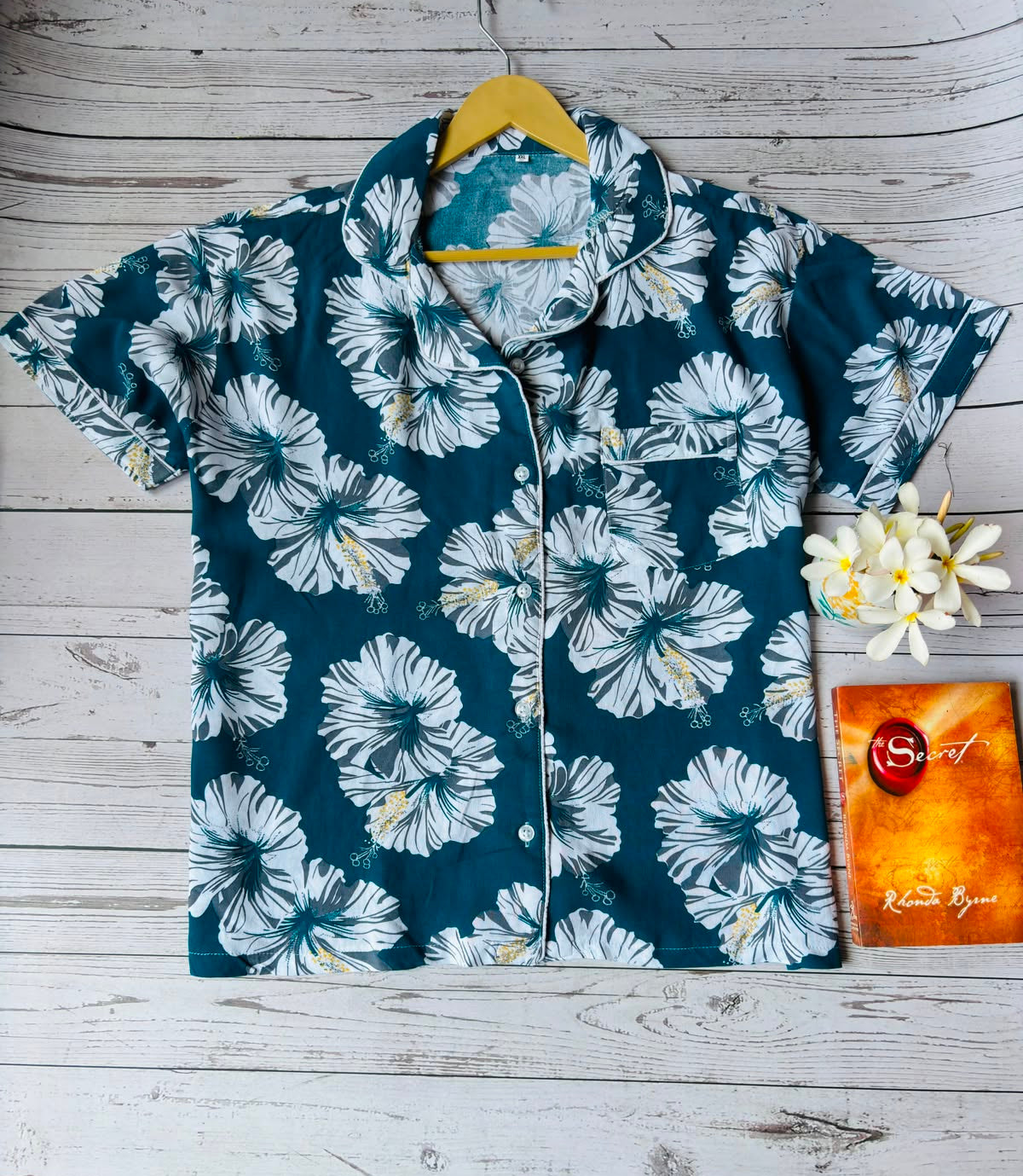 Floral patterned shirt on a hanger with a wooden background