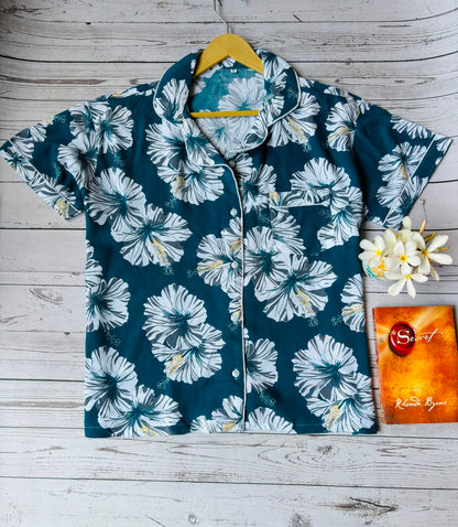 Floral patterned shirt on a hanger with a wooden background